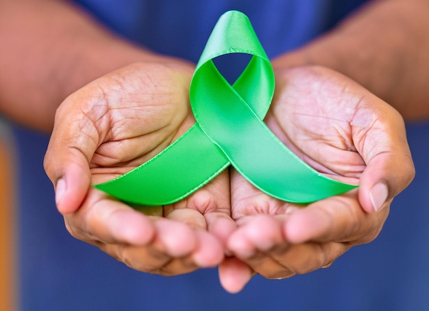 Foto fita verde colocada nas mãos humanas dia mundial da saúde mental