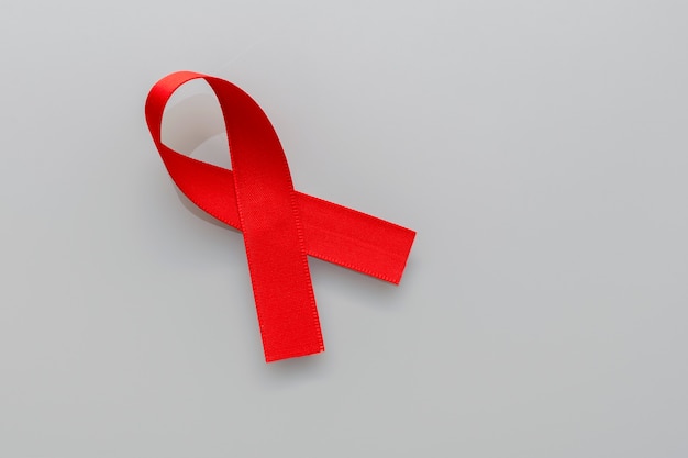 Foto fita vermelha da campanha de prevenção à aids, câncer de rim, câncer de cabeça e pescoço, hepatite. fita isolada no fundo branco. conscientização da doação de sangue.