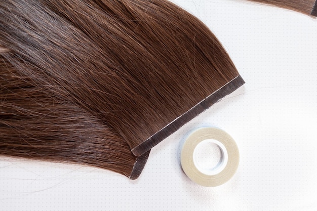 Fitas de cabelo para extensões na cabeça de uma mulher em casa. extensões de cabelo para engrossar o seu próprio.