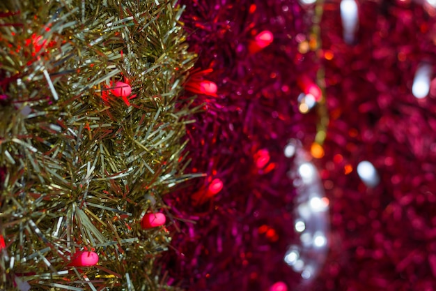 Fitas de guirlanda dourada e rosa com fundo de luzes vermelhas e brancas decoração colorida de natal