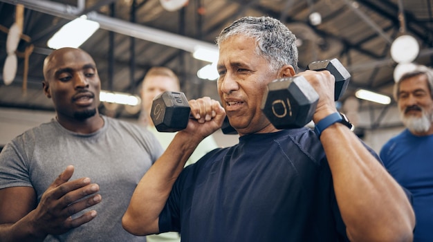 Fitness alter Mann mit Hantel und Hilfe von Trainer oder Personal Trainer mit Kraft beim Gewichtheben und Fitnessstudio im Ruhestand Gesundheitsübungen und Training im Seniorensportverein und Coaching-Opa