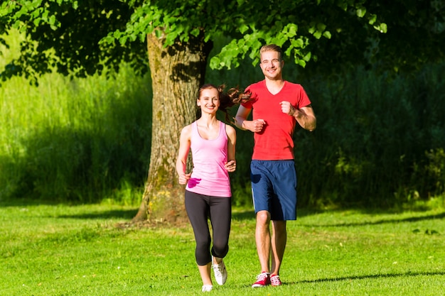 Fitness amigos corriendo juntos por el parque