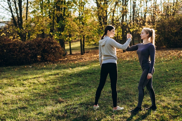 Fitness ao ar livre, duas meninas, de mãos dadas, cara a cara.