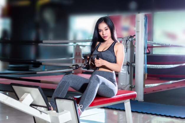 Fitness Asiatische Frauen, die Übungen mit Rudergerät (Seat Cable Rows Machine) im Sportstudio-Interieur und Fitness-Gesundheitsclub mit Sportübungsgeräten durchführen