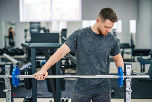 Fitness attraktives Manntraining im Fitnessstudio. Gesunder hübscher junger Trainer, der in der Turnhalle arbeitet.