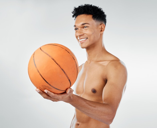 Fitness de baloncesto y hombre negro en ejercicio de entrenamiento de estudio y bienestar con una sonrisa para la competencia deportiva Músculo de poder y atleta feliz jugador de baloncesto o modelo con una pelota para entrenamiento de juego