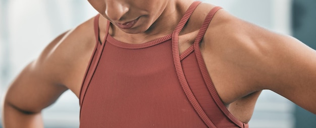 Fitness cansado y respirando con los hombros de una mujer negra en el gimnasio después de un entrenamiento para la salud Ejercicio agotado y respirando con un atleta entrenando para el bienestar o un estilo de vida saludable