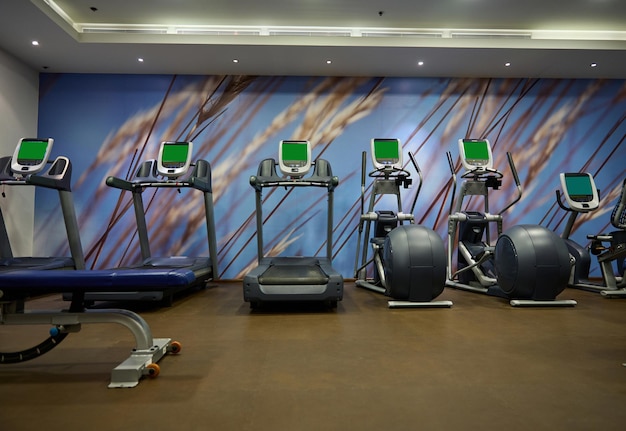 Foto fitness-center-interieur mit laufband. moderner fitnessraum mit geräten.