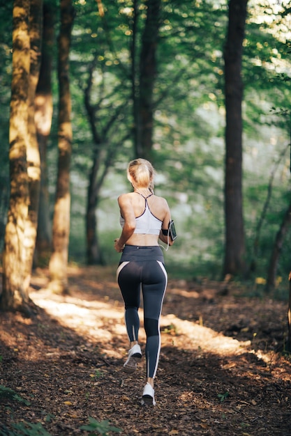 Fitness deporte mujer corriendo en la carretera por la mañana