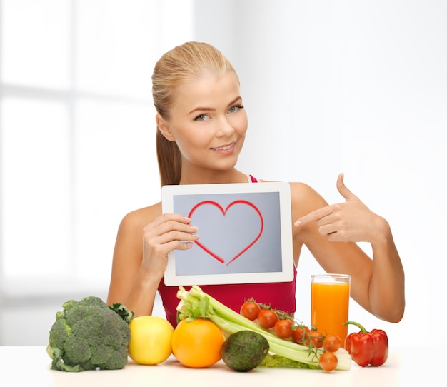 Foto fitness, dieta, tecnología, salud y concepto de comida - mujer deportiva con frutas y verduras apuntando a tablet pc
