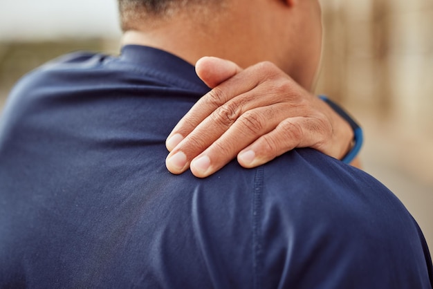 Fitness dolor de espalda y hombre con la mano en el músculo del hombro para masaje de apoyo y alivio durante el ejercicio o el entrenamiento Entrenamiento deportivo de salud y bienestar y lesiones deportivas dolorosas con las manos en la espalda