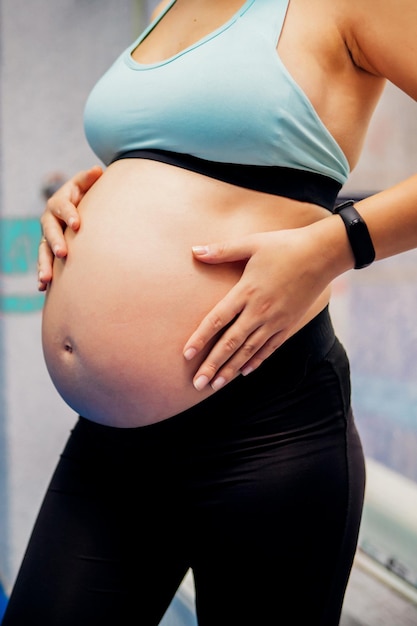 Fitness e estilo de vida saudável durante a gravidez Uma menina grávida com uma barriga grande pratica esportes durante o terceiro trimestre Uniforme esportivo Saúde Esperando um bebê