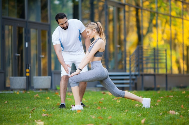 Fitness, entrenador personal toma notas mientras una mujer hace ejercicio al aire libre