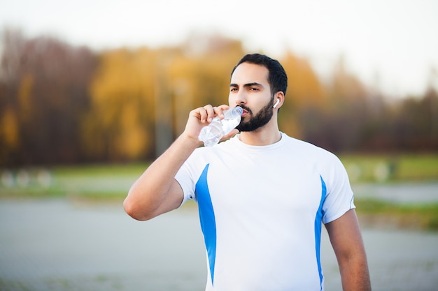 Fitness. Erschöpfter Läufermann, der auf dem Park nach Training stillsteht