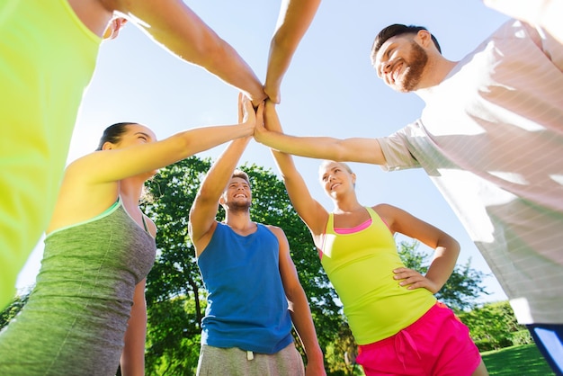 fitness, esporte, amizade e conceito de estilo de vida saudável - grupo de amigos adolescentes felizes ou desportistas fazendo mais cinco ao ar livre