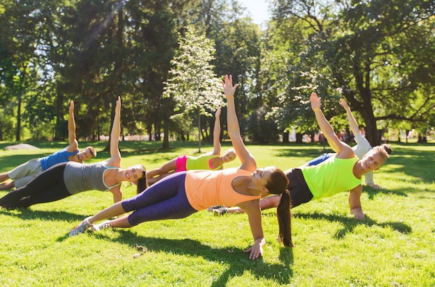 fitness, esporte, amizade e conceito de estilo de vida saudável - grupo de amigos adolescentes felizes se exercitando no campo de treinamento