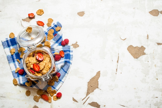 Fitness Essen. Müsli mit Beeren in einem Glas auf dem Stoff. Auf rustikalem Hintergrund.