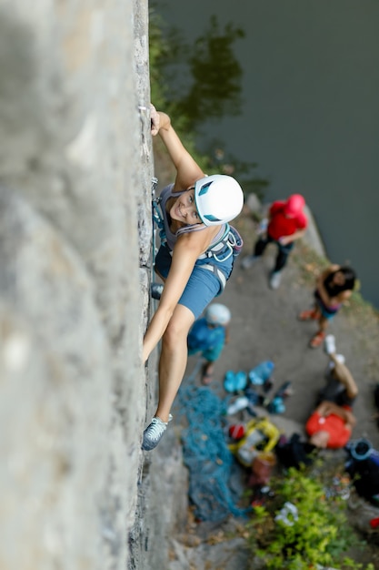 Fitness, Extremsport und gesundes Lifestyle-Konzept - Kletterer überwindet anspruchsvolle Kletterroute. Ein Mädchen klettert auf einen Felsen. Frau im Extremsport tätig. Extremes Hobby.