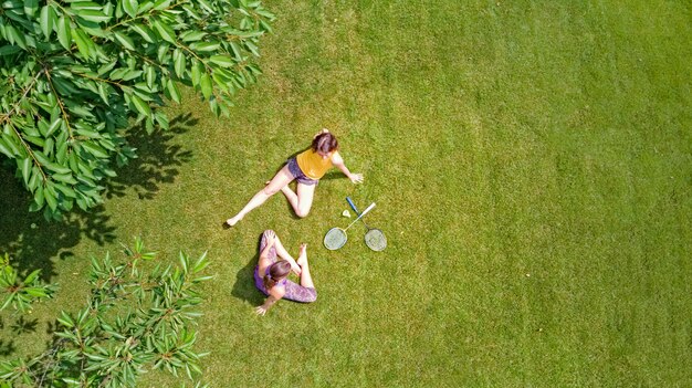 Fitness familiar y deporte al aire libre, activo madre e hija adolescente jugando bádminton en el parque, vista aérea superior