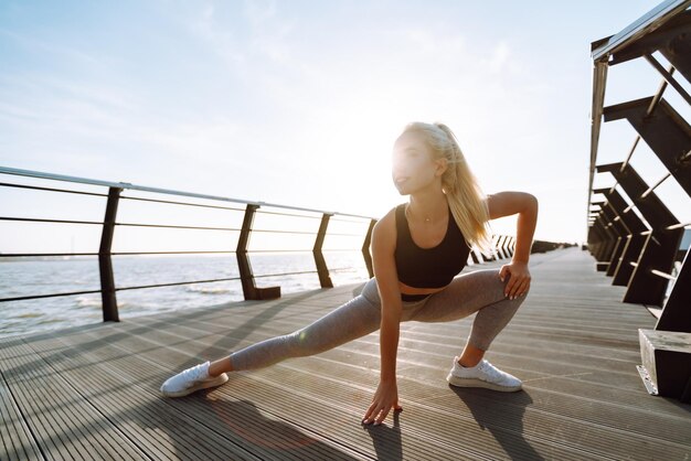 Fitness-Frau, die Sportübungen am Strandpier macht Gesunder Lebensstil Sport Aktives Leben