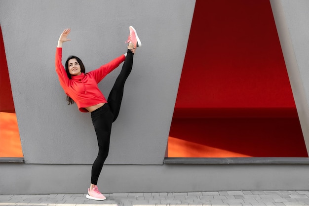 Fitness-Frau ist Fitness-Stretching und Training im Freien in der städtischen Umgebung