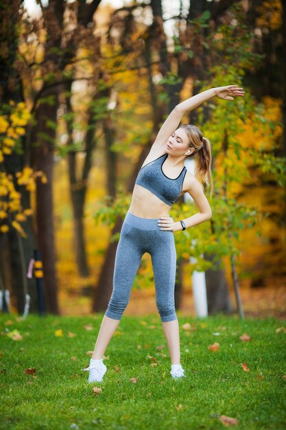 Fitness-Frau macht Dehnübungen im Park