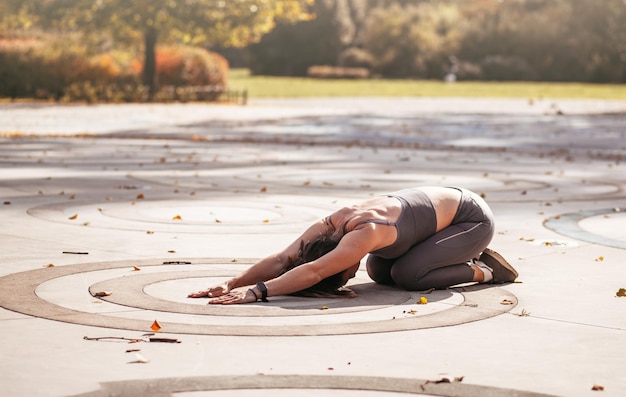 Fitness-Frau macht Yoga-Übungen, die sich im Sommerpark dehnen Sport Gesundes Konzept