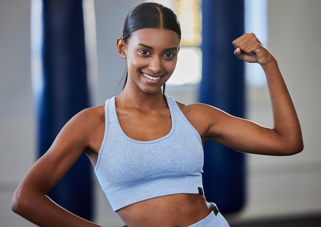 Fitness fuerte y músculo de mujer o culturista en retrato con motivación de poder y energía en estudio de gimnasio para entrenamiento o ejercicio Objetivos corporales de un deportista indio o atleta con flexión de brazo