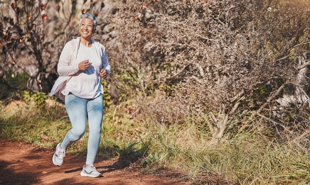 Foto fitness glückliche und ältere frau, die in der natur für cardio-morgenmotivation und marathontraining in australien läuft freedom wellness und ältere läufer mit einem lächeln für outdoor-übungen in einem park