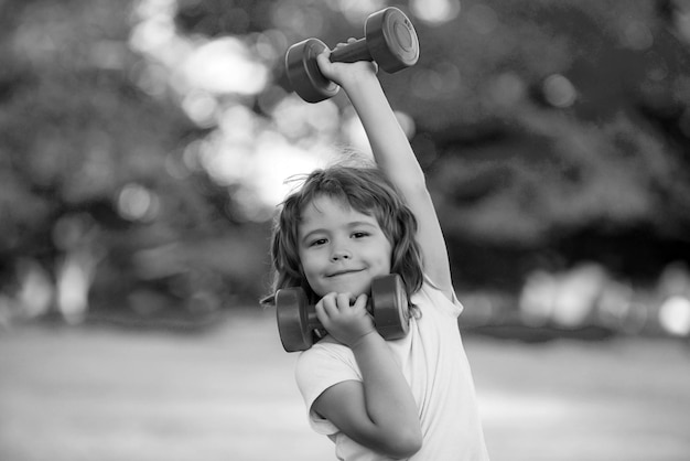 Fitness Hanteln Kind Übung Training im Freien Junge sportliches Kind mit Hanteln gesunde Aktivitäten ki