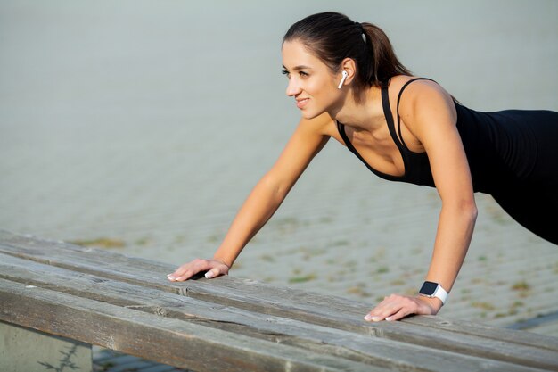 Fitness, hermosa joven con músculos perfectos