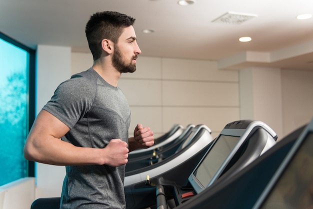 Foto fitness hombre corriendo en caminadora