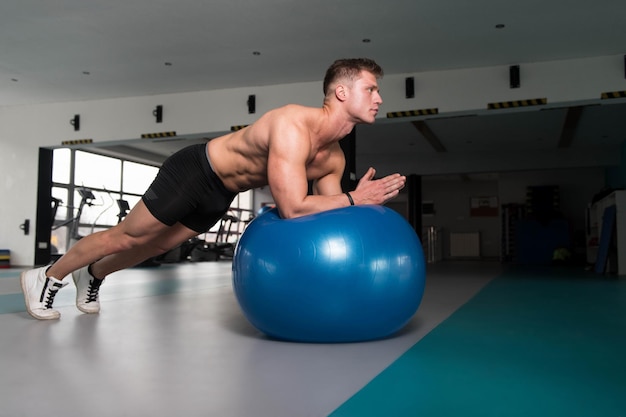 Fitness hombre haciendo ejercicio abdominal en bola