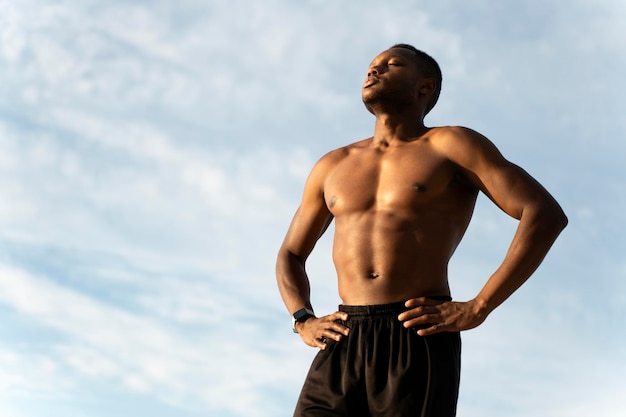 Fitness hombre multirracial disfrutando del sol en la playa en un día de verano