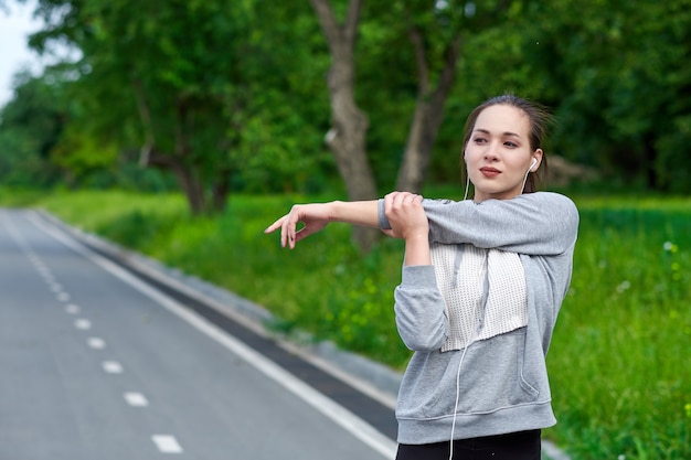 Fitness junge asiatische Frau, die Hände nach dem Laufen streckt.