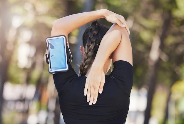 Fitness-Läuferin oder Frau, die ihre Arme ausstreckt, bereit für Trainingsübungen oder Körperbewegungen. Rückansicht einer Sportlerin oder eines gesunden Mädchens beim Laufen, Aufwärmen für Flexibilität oder Beweglichkeit im Park