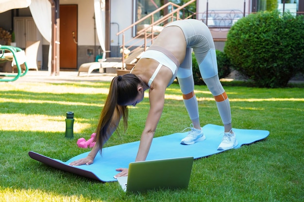 Fitness linda mulher magra fazendo exercícios de alongamento fitness ao ar livre em casa Esporte estilo de vida saudável