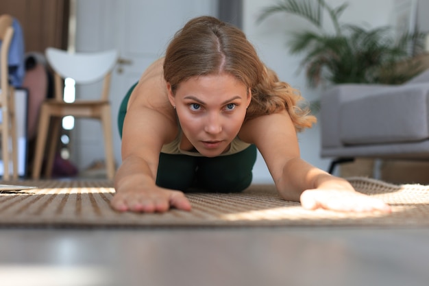 Fitness linda mulher magro fazendo exercícios de alongamento de fitness em casa na sala de estar. Ficar em atividades de casa. Esporte, estilo de vida saudável.