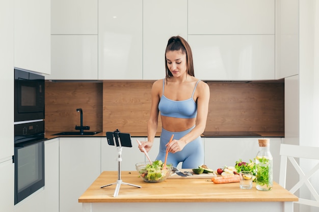 Fitness-Mädchen, das Salat in der Küche vorbereitet