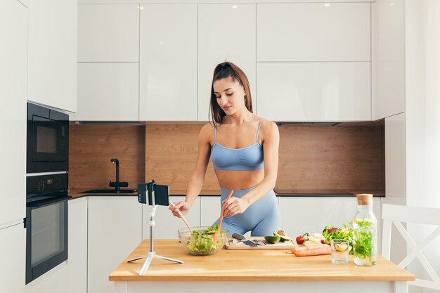 Fitness-Mädchen, das Salat in der Küche vorbereitet