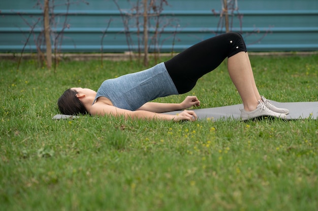 Fitness. Mädchen, das Verbrauchsteuern auf dem Rasen im Hof ihres Hauses macht