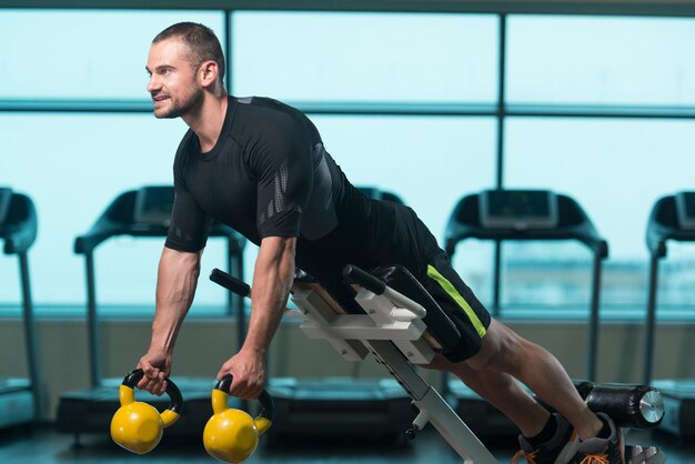 Fitness-Mann arbeitet mit Kettlebell in einer Kettlebell-Übung im Fitnessstudio