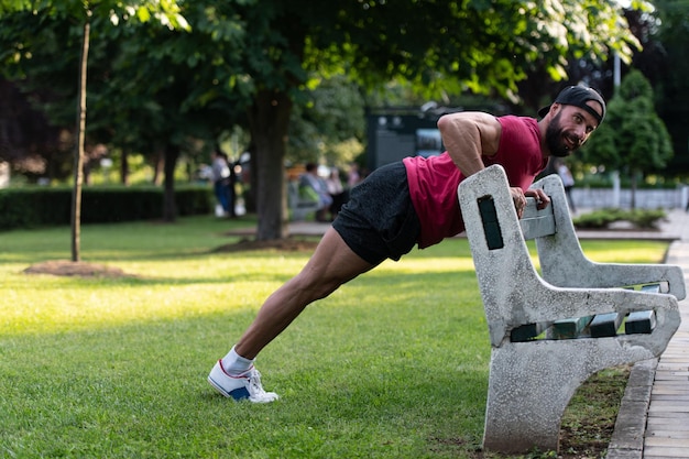 Fitness-Mann, der Liegestütze in einem Park ausübt