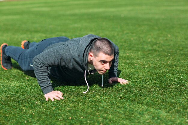 Fitness-Mann-Planken-Training im Park im Freien.