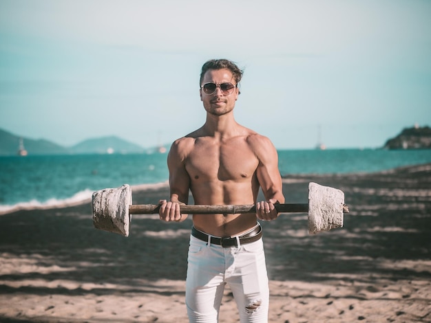 Foto fitness modelo masculino trabajando en la playa