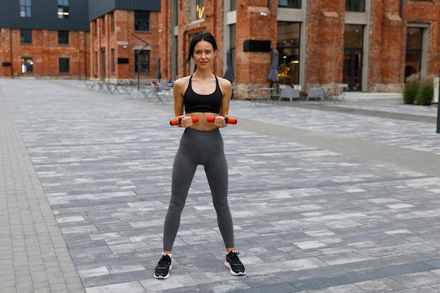 Fitness mujer al aire libre haciendo ejercicio con pesas