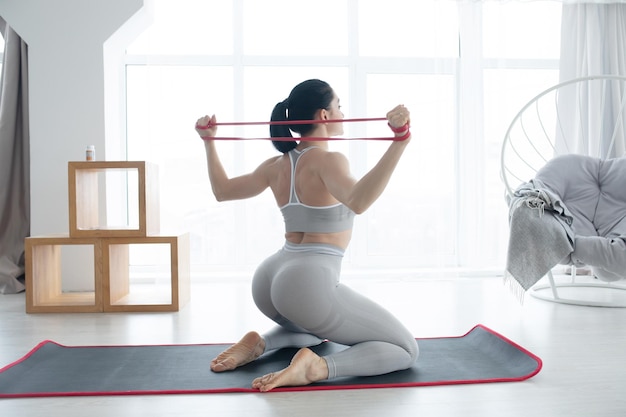 Fitness mujer atleta y culturista sosteniendo expansor o mini bandas Concepto deportivo en casa