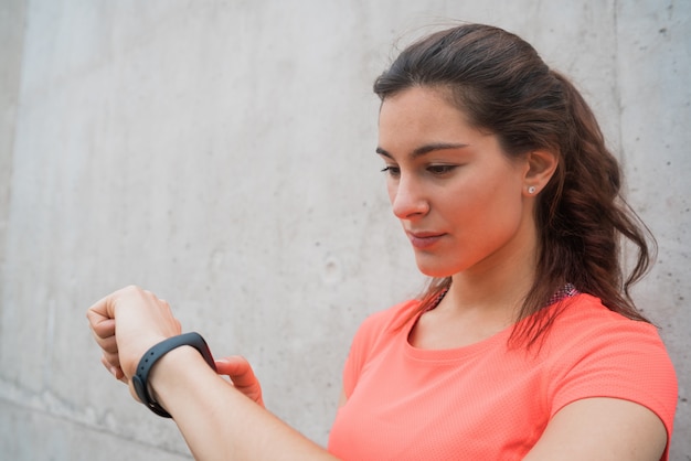 Fitness mujer comprobando el tiempo en reloj inteligente