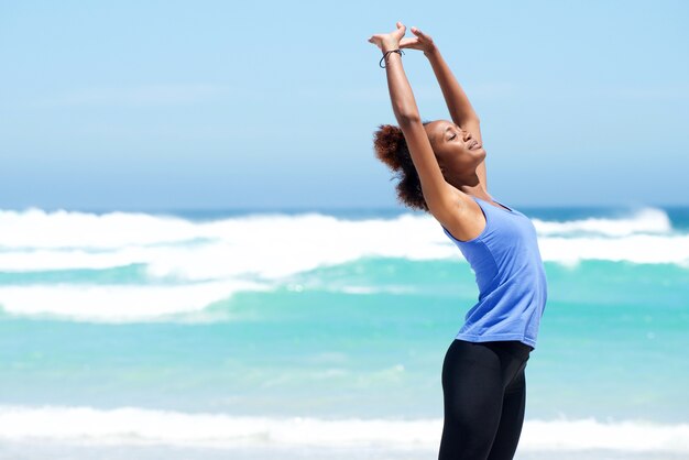 Fitness mujer estirando en la playa