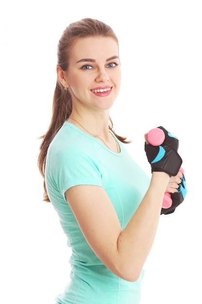 Fitness mujer en guantes y pesas sobre un fondo blanco.